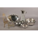 A group of metalwares, to include twin handled silver plate pot, brass easels, cut glass carafe.