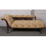 A Victorian chaise longue raised on turned supports. Upholstery beyond salvage.
