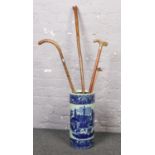 A ceramic stick stand (approx 46 cm height 20 cm width) to include a collection of wooden walking