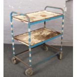 A three tier steel trolley. Missing one shelf.