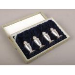 Four cased silver pepper pots, stamped sterling. 58g.