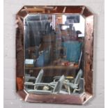 A bevel edge wall mirror with peach coloured glass edge. 75cm x 60cm.