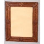 A late 19th / early 20th century Tramp Art frame. Incorporating 12 courses of carving and 4