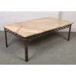 A large marble top coffee table with wrought iron base.