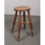 An oak stool on turned supports.