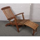 A teak folding steamer lounger with metal fittings. Label for Mesch by Hartman. One metal pin on the