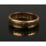 A Victorian 18ct gold band. Assayed Birmingham 1872 4.36 grams, size J. Worn inscription to the