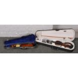 A cased electric violin along with a cased child's violin.