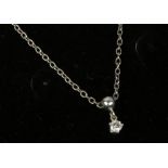 A white metal mounted solitaire diamond pendant on chain.