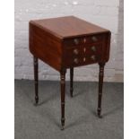 A Regency mahogany two drawer lamp table. With drop leaves and raised on tapering ring turned