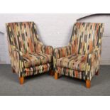 A pair of modern arm chairs, with striped upholstery.