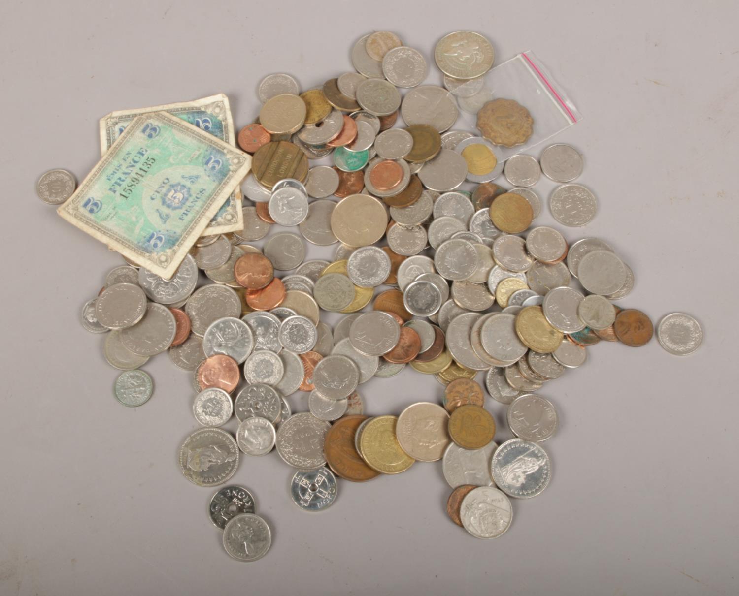 A box of mixed foreign coins, dollar, Kroner, Francs examples