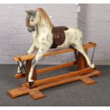 A painted composite rocking horse on pine base. Makers label for Haddon Rockers, Oxfordshire,