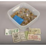 A box of coins and banknotes to include foreign coins, ten shillings banknote etc.