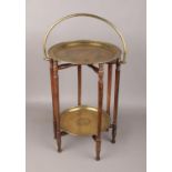 An Indian brass two tier table with folding mahogany base.