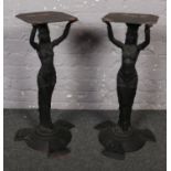 A pair of Egyptian style cast iron table bases of figural form.