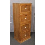 A vintage pine bank of four filing drawers with enamelled letter plates. 156cm tall x 59cm wide.