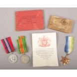 Three British World War II campaign medals, War, Defence and Atlantic Star, packet and letter of