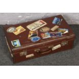 A leather suitcase with travel stickers.