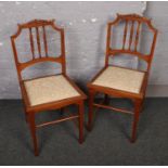 A pair of Edwardian satinwood carved and inlaid salon chairs.