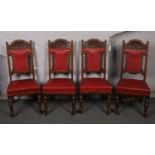 A set of four Victorian carved oak and red leather dining chairs.