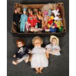 A box of dolls including Barbies and Action Man figures.