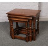 A nest of three solid oak occasional tables.