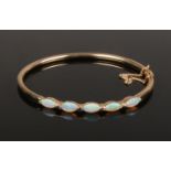 A 9ct gold five stone opal bangle. 6.5 grams gross weight.