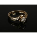 A 9ct gold diamond cluster ring set on twist shoulders. Size M.