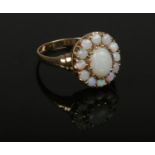 A 9ct gold opal cluster ring with stepped shoulders. Size R.