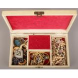A vintage musical jewellery box containing vintage costume jewellery, necklaces, dress clips etc.