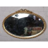 An oval gilt framed bevel edge wall mirror.