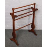 A Victorian mahogany towel rail with pierced sides and raised on scroll supports.