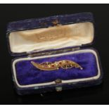 A Victorian cased 9ct gold scroll form brooch set with garnets and pearls. Assayed Birmingham