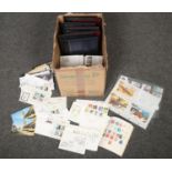 A box containing first day covers, stamps, postcards, empty albums etc.