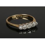 An 18ct gold and platinum ring, set with five diamonds, size M 1/2. (2.07g). Centre stone approx 0.