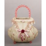A novelty tablelamp formed as a handbag. With beadwork handle and feet and having embroidered lace