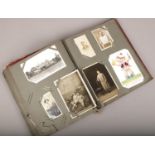 A postcard album containing vintage postcards to include monochrome, colour, silk examples etc.