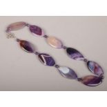 A silver and purple hardstone necklace.