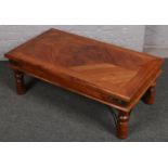 A modern hardwood coffee table with metal mounts.