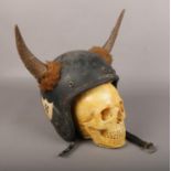 A vintage Hell's Angels style motorbike helmet and heavy cast plaster model of a skull.