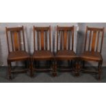 A set of four oak leather seat dining chairs.