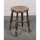 A vintage wooden stool with turned supports. Cracks to legs. Knocks and signs of wear.