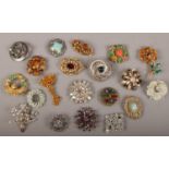 Twenty vintage costume jewellery brooches including coloured and white paste examples.