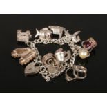 A silver charm bracelet with heart shaped clasp, 43.7 grams gross.