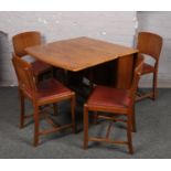 A drop leaf dining table and set of four chairs, along with a Lloyd Loom chair.