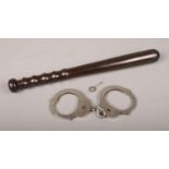 A set of steel handcuffs, by Master Lock Company, along with a Hiatt & Co turned wooden truncheon.