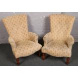 A pair of cream upholstered armchairs.