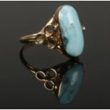 A 14ct gold and larimar ring. With a large oval stone set on openwork trefoil shoulders. Size L 1/2.