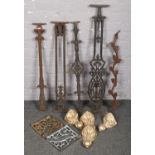 A collection of cast iron stair brackets along with four iron ball and claw bath feet.